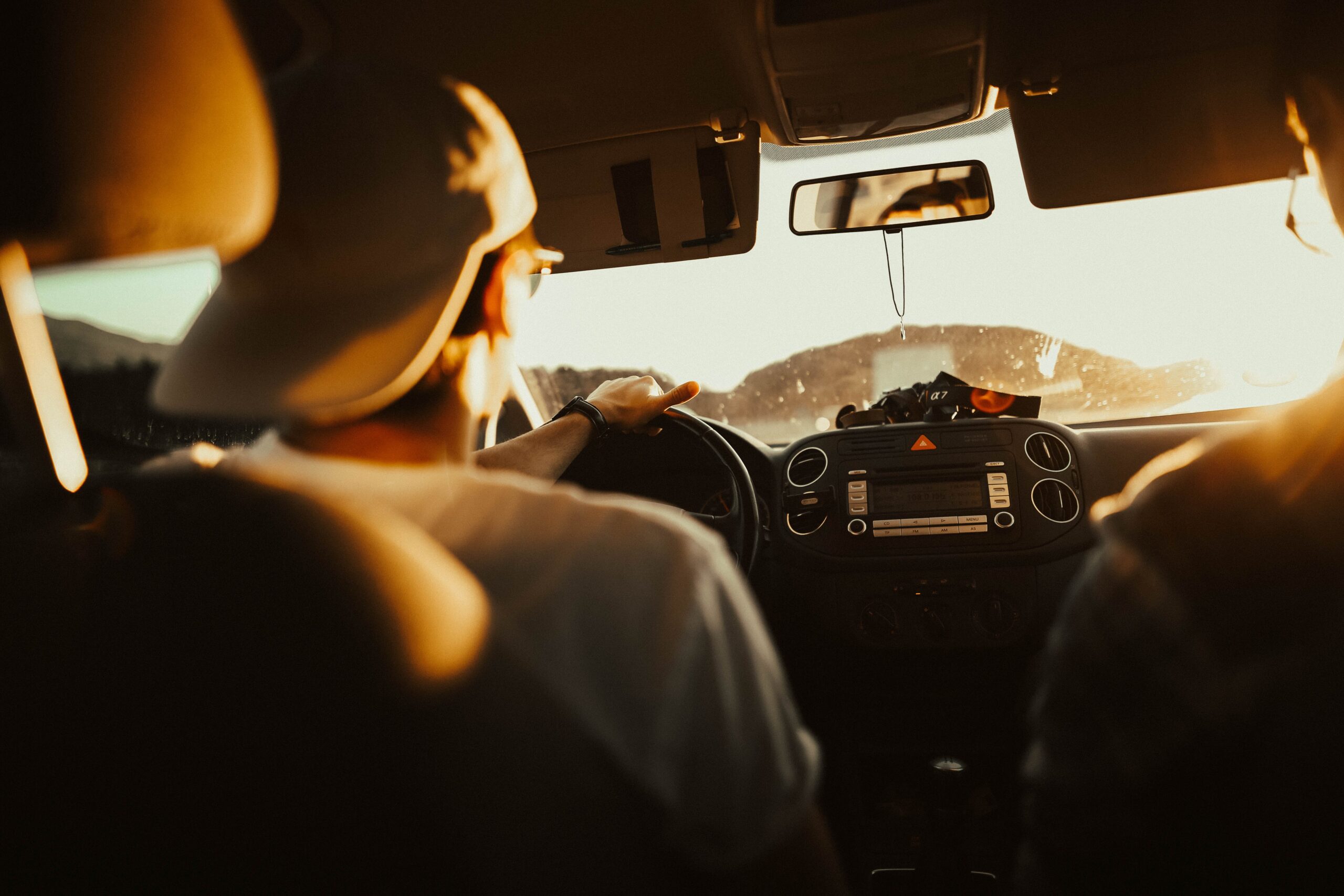 Valentine's 2024 - Couple in car, cruising at sunset with vibrant sky in background.