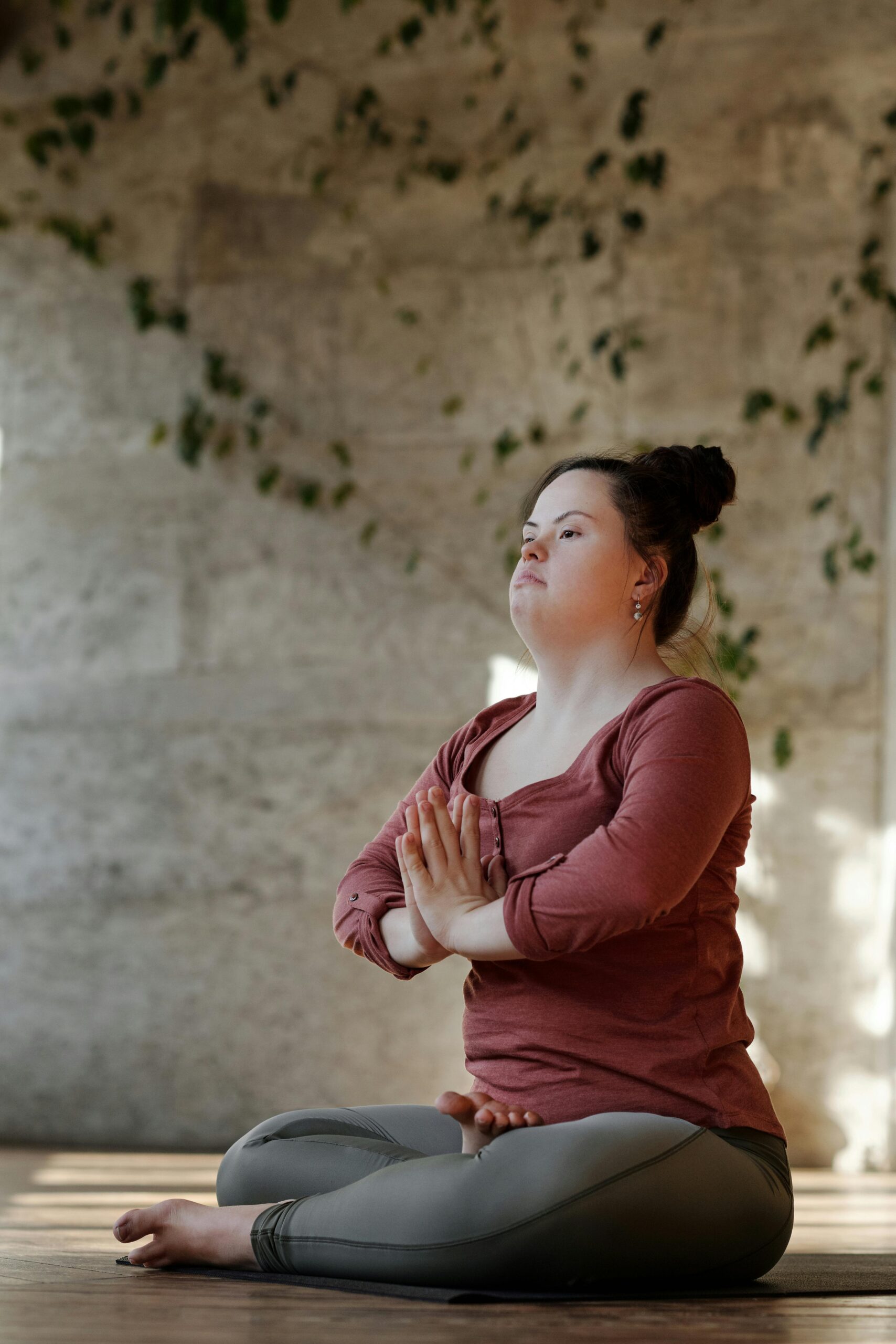 morning meditation - A woman meditating in a yoga position, with her legs crossed and her hands in prayer position.